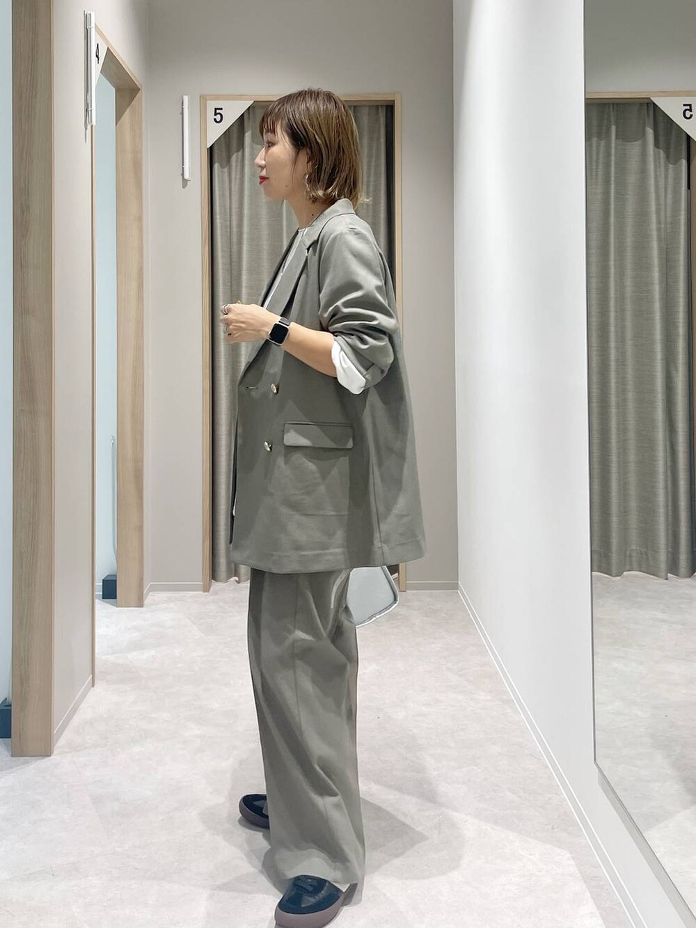 ブラック系のスニーカー、ベージュ系のテーラードジャケット、ベージュ系のスラックスを着用したレディースの秋コーディネートの4枚目の写真