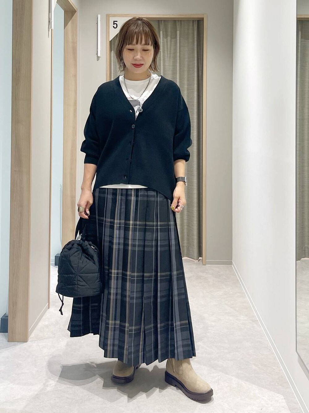 ブラック系のカーディガン/ボレロ、ブラック系のハンドバッグ、ホワイト系のTシャツ/カットソーを着用したレディースの秋コーディネートの5枚目の写真