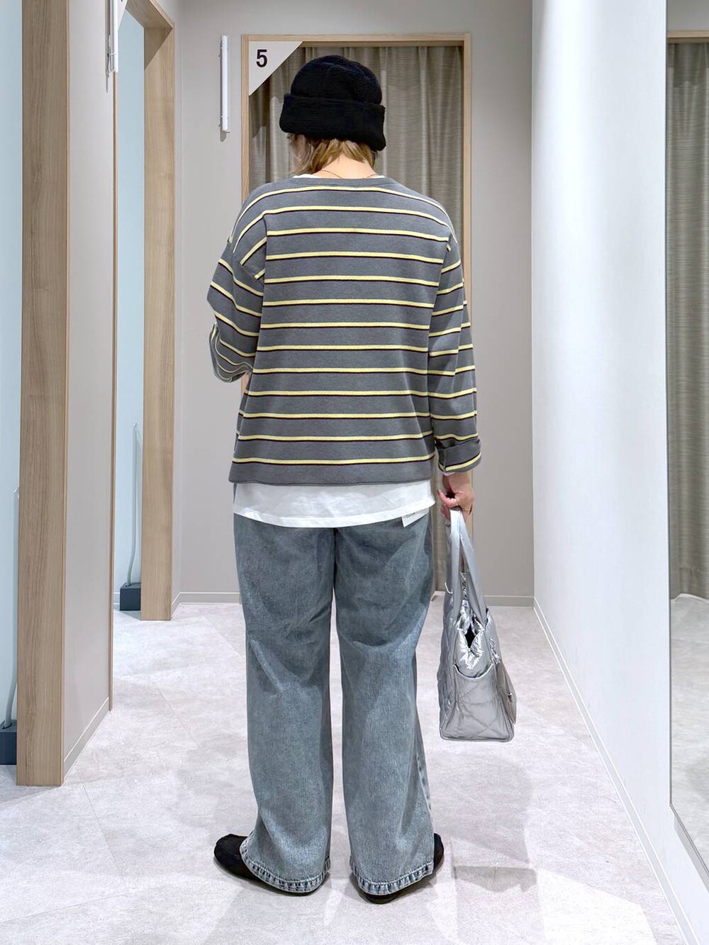 シルバー系のトートバッグ、ホワイト系のTシャツ/カットソー、ブラック系のモカシン/デッキシューズを着用したレディースの冬コーディネートの3枚目の写真