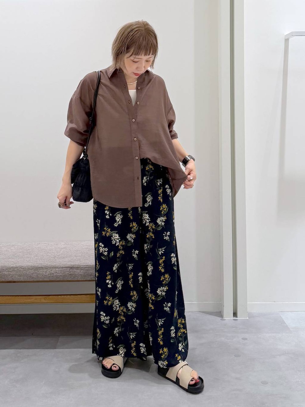ブラック系のトートバッグ、ブルー系のその他パンツ、ブラウン系のシャツ/ブラウスを着用したレディースの夏コーディネートの2枚目の写真