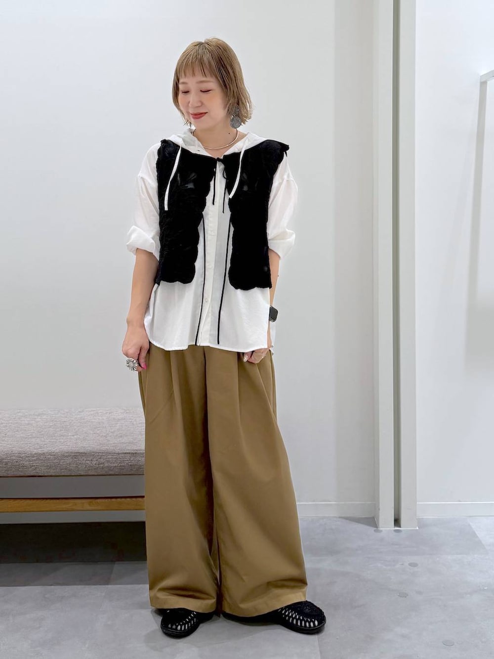 ブラック系のベスト、ホワイト系のTシャツ/カットソー、ブラウン系のその他パンツを着用したレディースの夏コーディネートの2枚目の写真