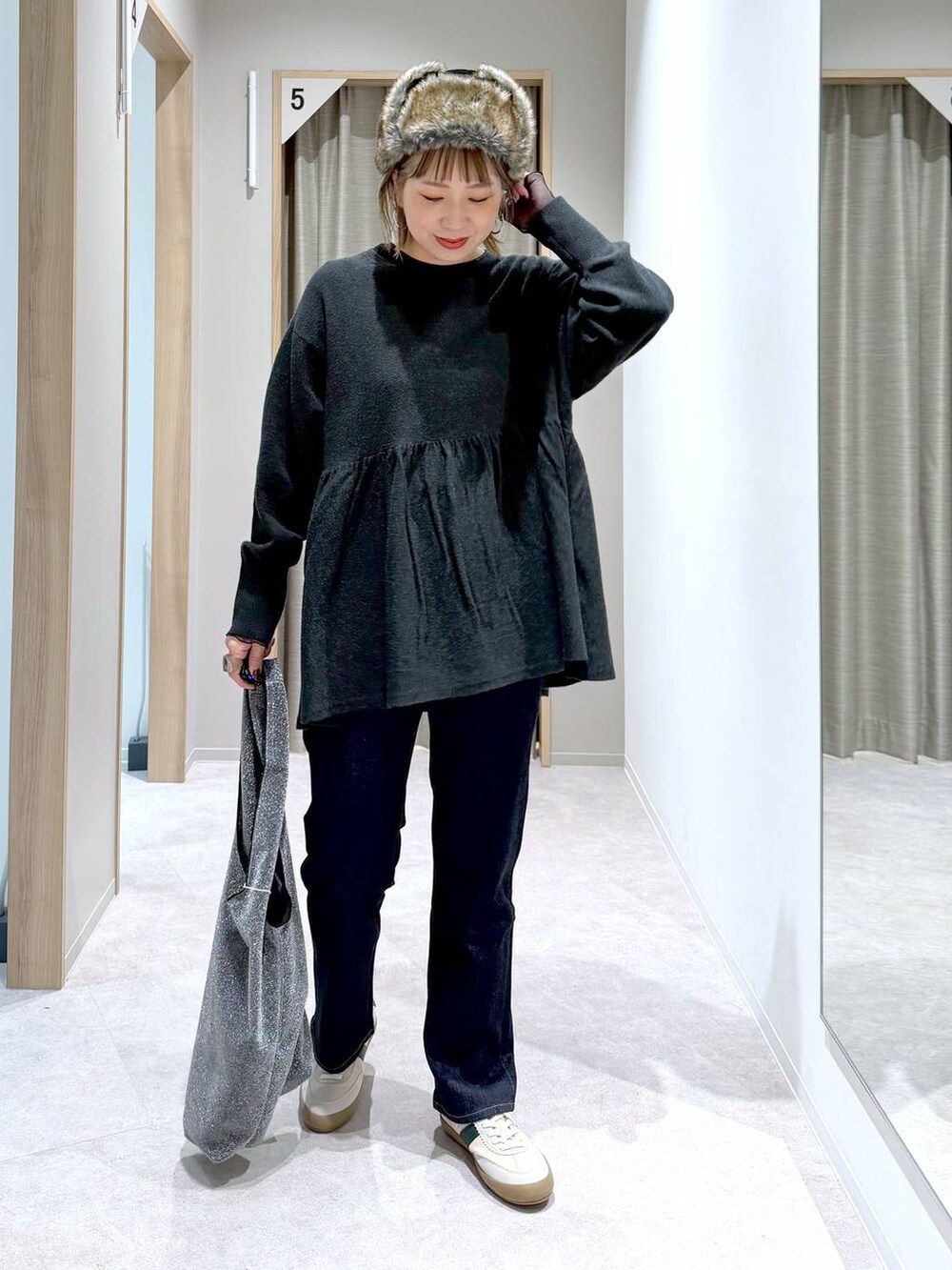 ブルー系のデニムパンツ、グレー系のトートバッグ、ベージュ系のスニーカーを着用したレディースの冬コーディネートの4枚目の写真