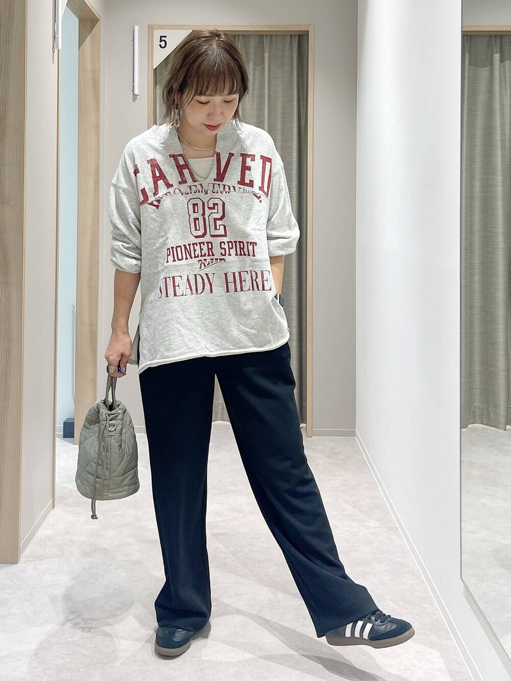 グリーン系のハンドバッグ、シルバー系のネックレス、シルバー系のネックレスを着用したレディースの秋コーディネートの2枚目の写真