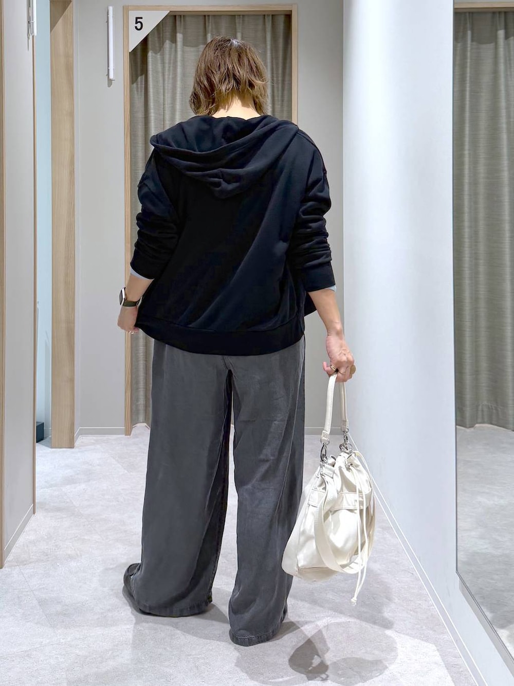 ブラック系のその他シューズ、ホワイト系のショルダーバッグ、ブルー系のニット/セーターを着用したレディースの春コーディネートの2枚目の写真