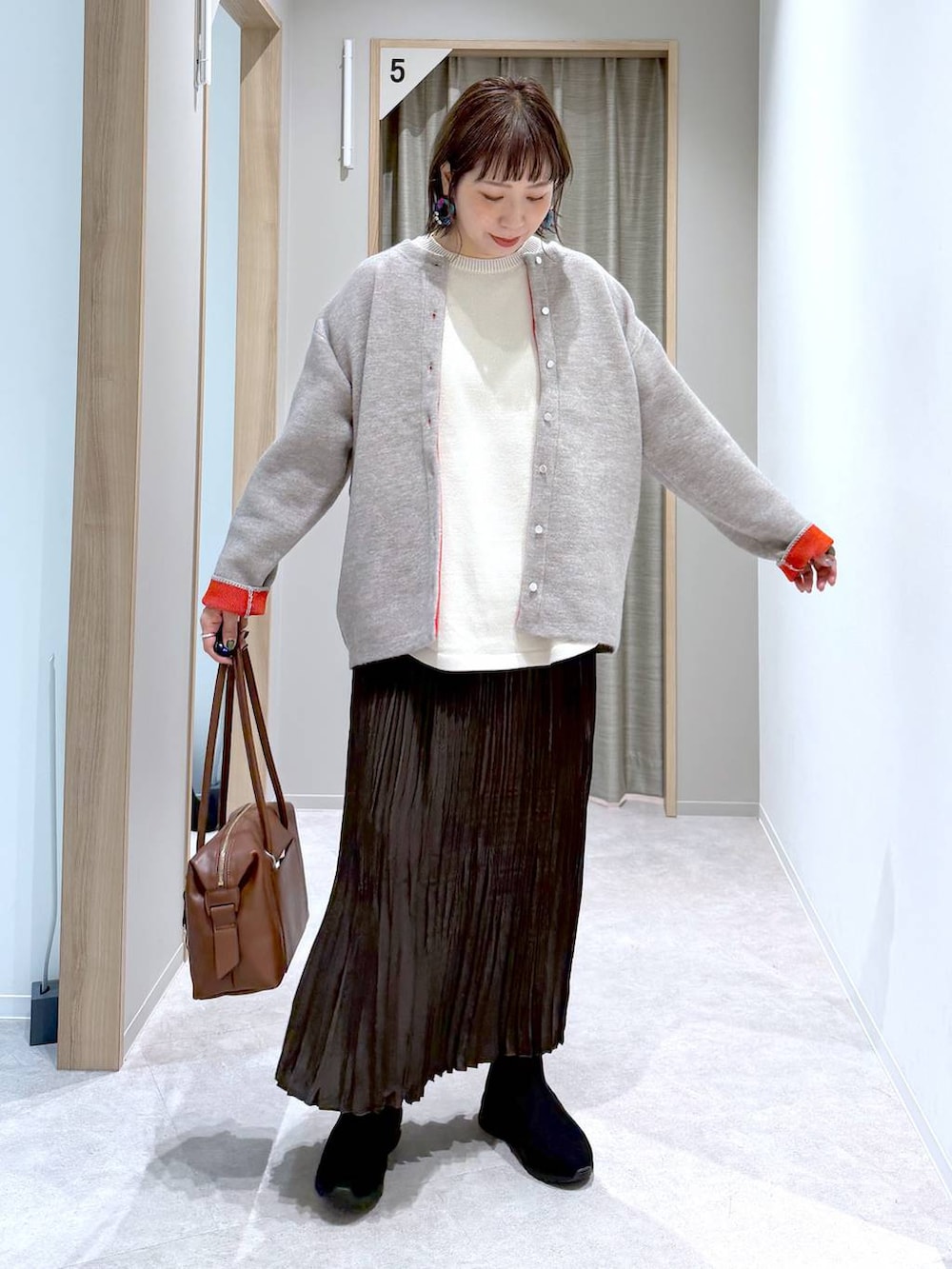 ベージュ系のニット/セーター、ブラウン系のボストンバッグ、ブラック系のブーツを着用したレディースの冬コーディネートの5枚目の写真