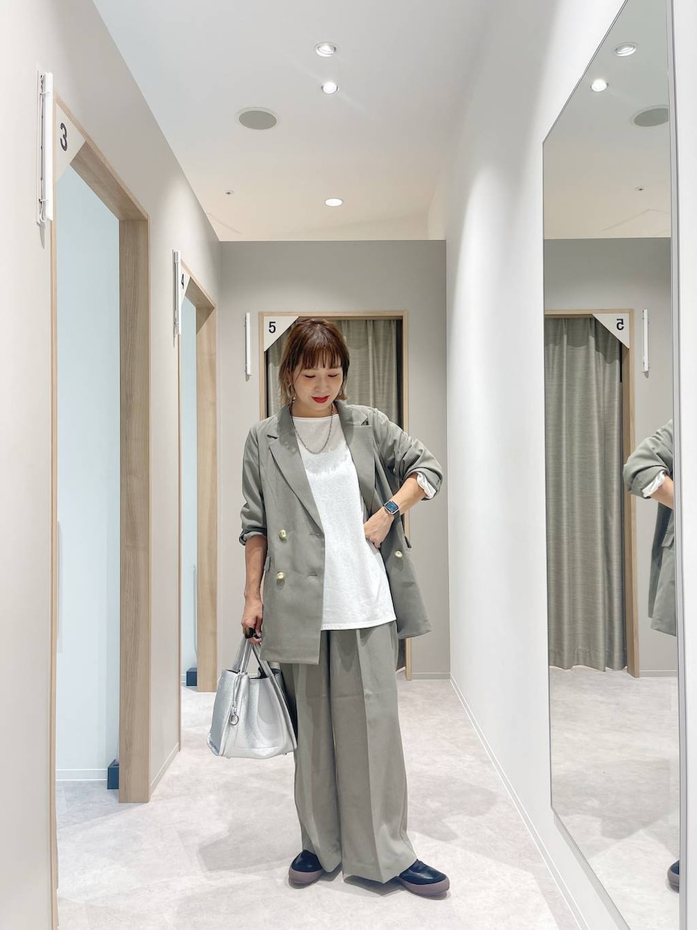 ブラック系のスニーカー、ベージュ系のテーラードジャケット、ベージュ系のスラックスを着用したレディースの秋コーディネートの7枚目の写真