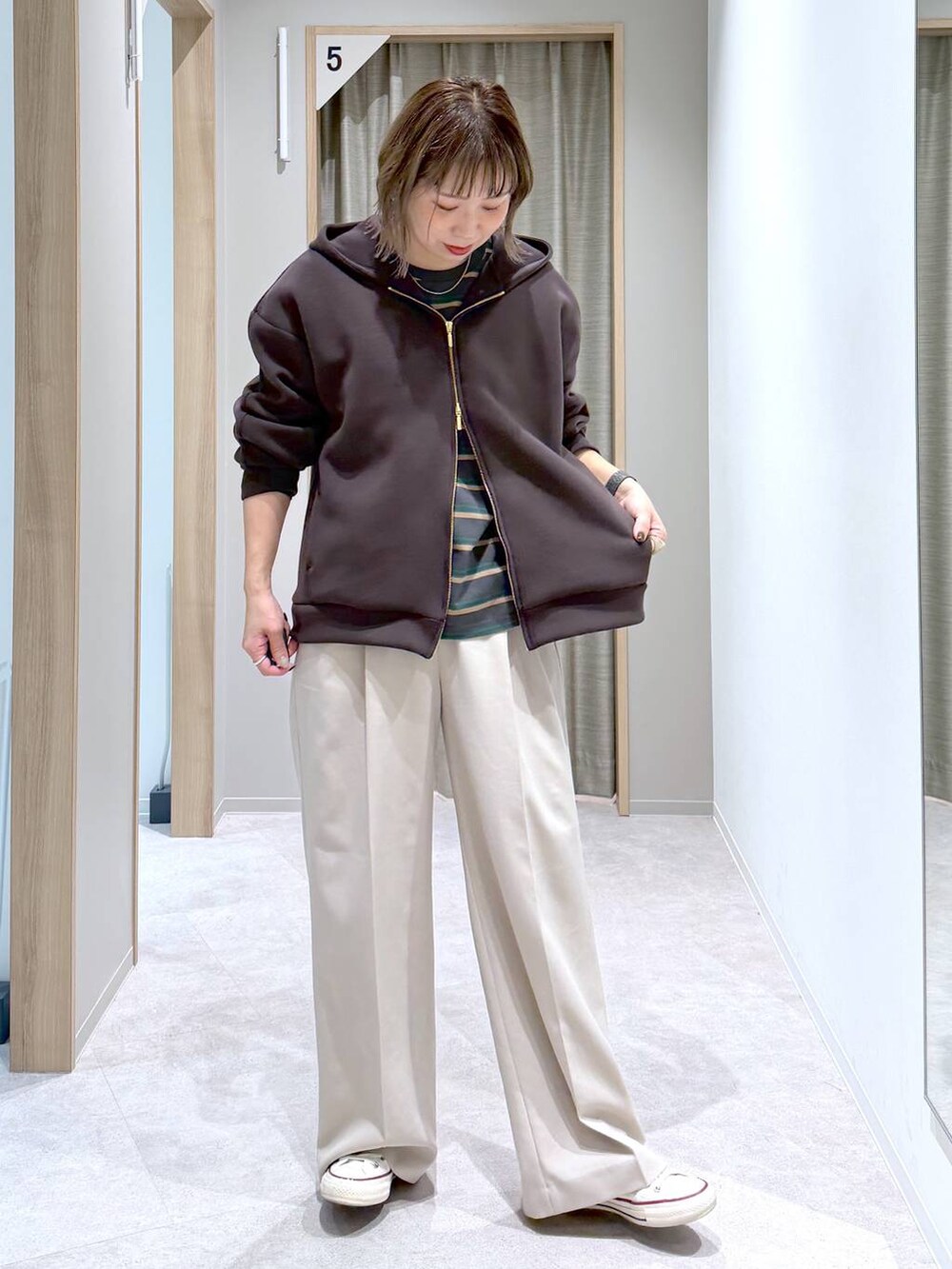 ベージュ系のその他パンツ、ブラウン系のパーカー、グレー系のTシャツ/カットソーを着用したレディースの冬コーディネートの6枚目の写真