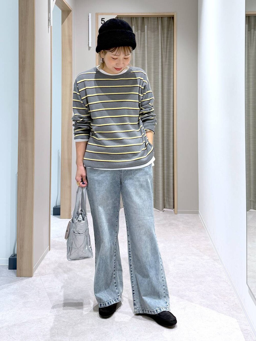 シルバー系のトートバッグ、ホワイト系のTシャツ/カットソー、ブラック系のモカシン/デッキシューズを着用したレディースの冬コーディネートの5枚目の写真