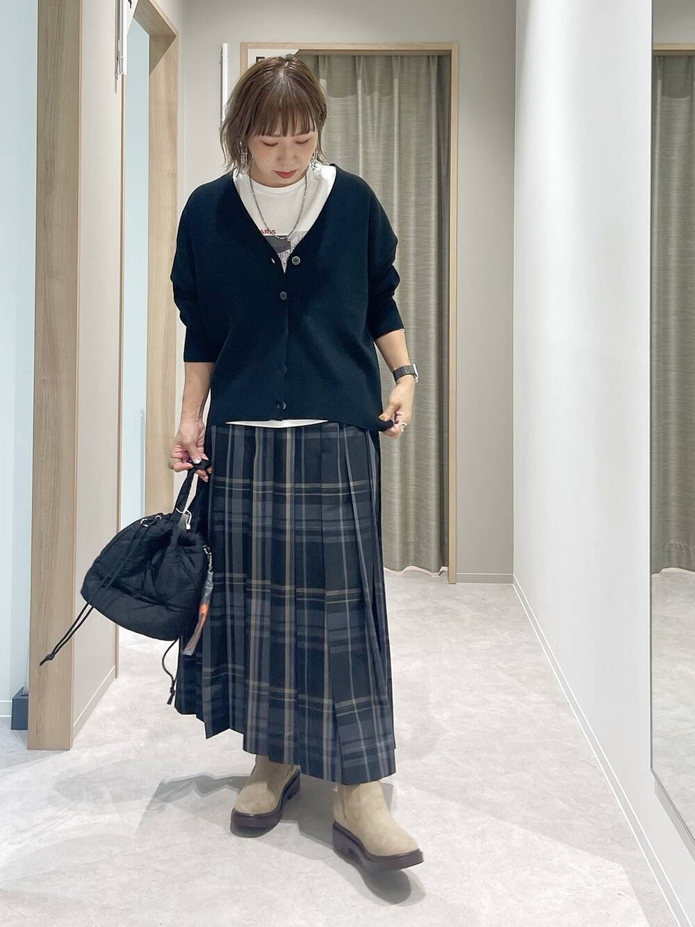 ブラック系のカーディガン/ボレロ、ブラック系のハンドバッグ、ホワイト系のTシャツ/カットソーを着用したレディースの秋コーディネートの4枚目の写真