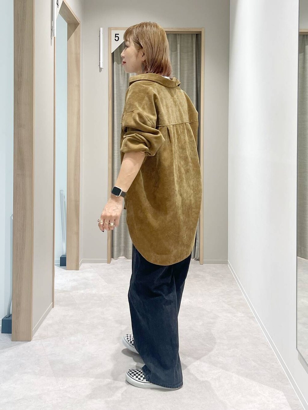 ホワイト系のタンクトップ、ブラック系のデニムパンツ、イエロー系のシャツ/ブラウスを着用したレディースの秋コーディネートの2枚目の写真