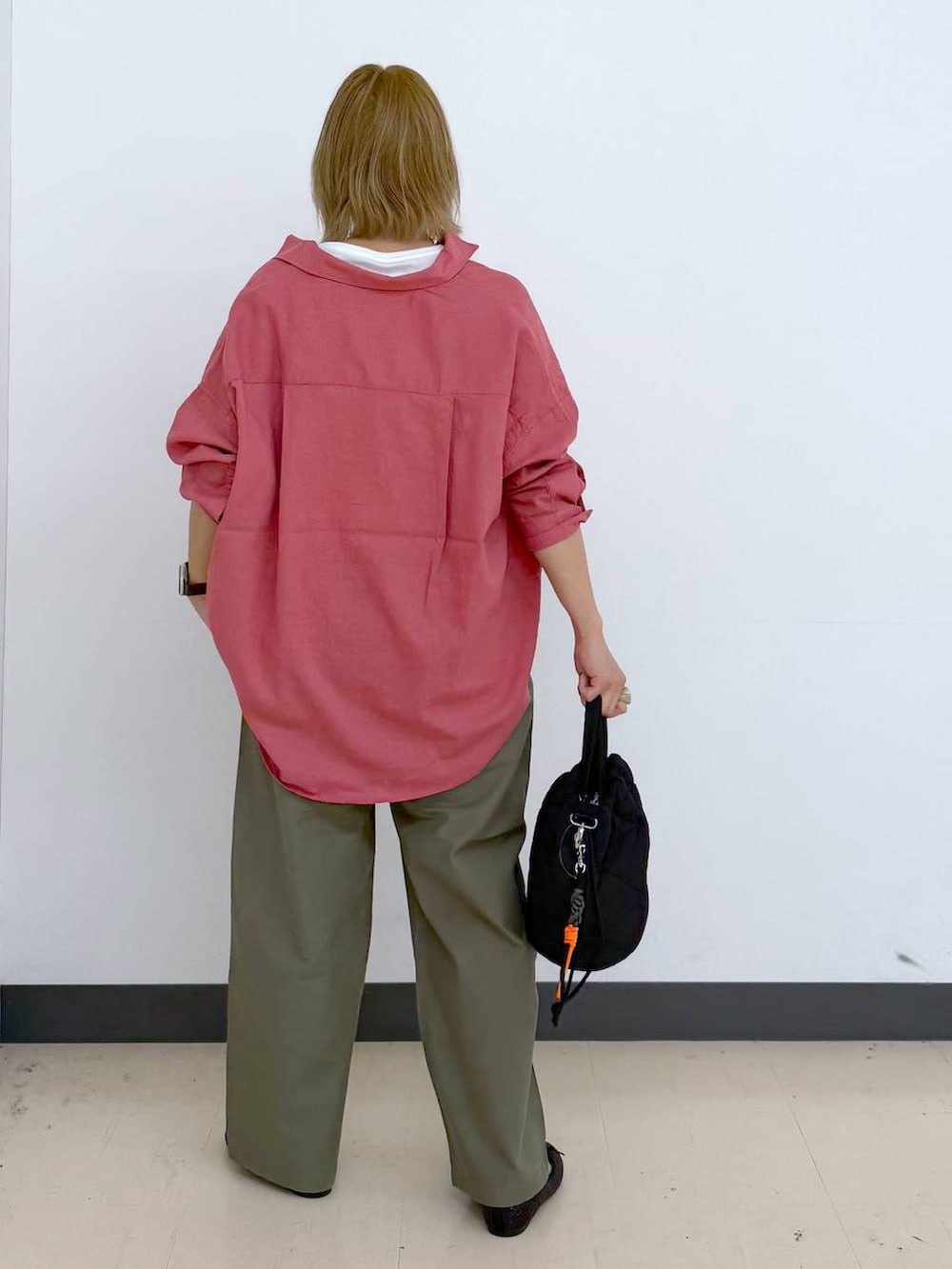 ブラック系のハンドバッグ、ピンク系のシャツ/ブラウス、グリーン系のその他パンツを着用したレディースの春コーディネートの2枚目の写真