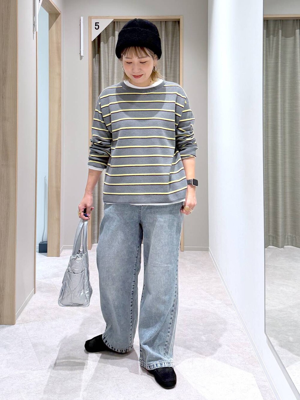 シルバー系のトートバッグ、ホワイト系のTシャツ/カットソー、ブラック系のモカシン/デッキシューズを着用したレディースの冬コーディネートの6枚目の写真