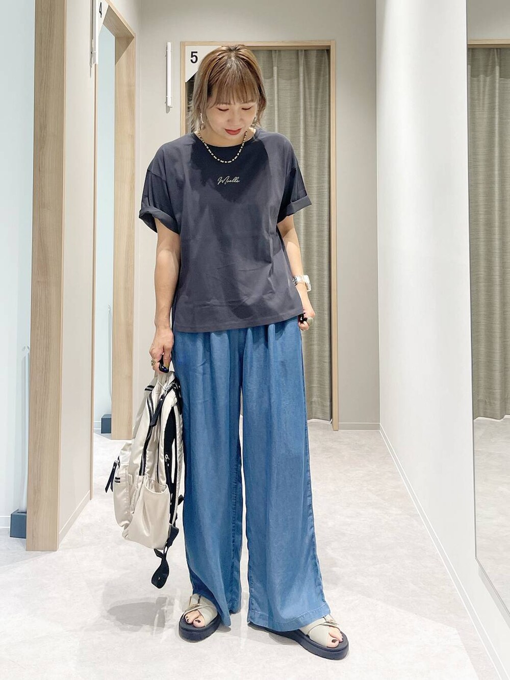 グレー系のTシャツ/カットソー、ホワイト系のバックパック/リュック、ベージュ系のサンダルを着用したレディースの夏コーディネートの4枚目の写真