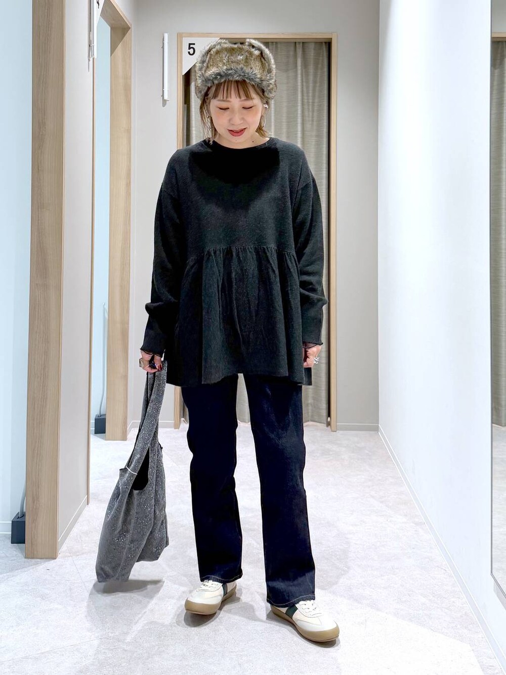 ブルー系のデニムパンツ、グレー系のトートバッグ、ベージュ系のスニーカーを着用したレディースの冬コーディネートの7枚目の写真