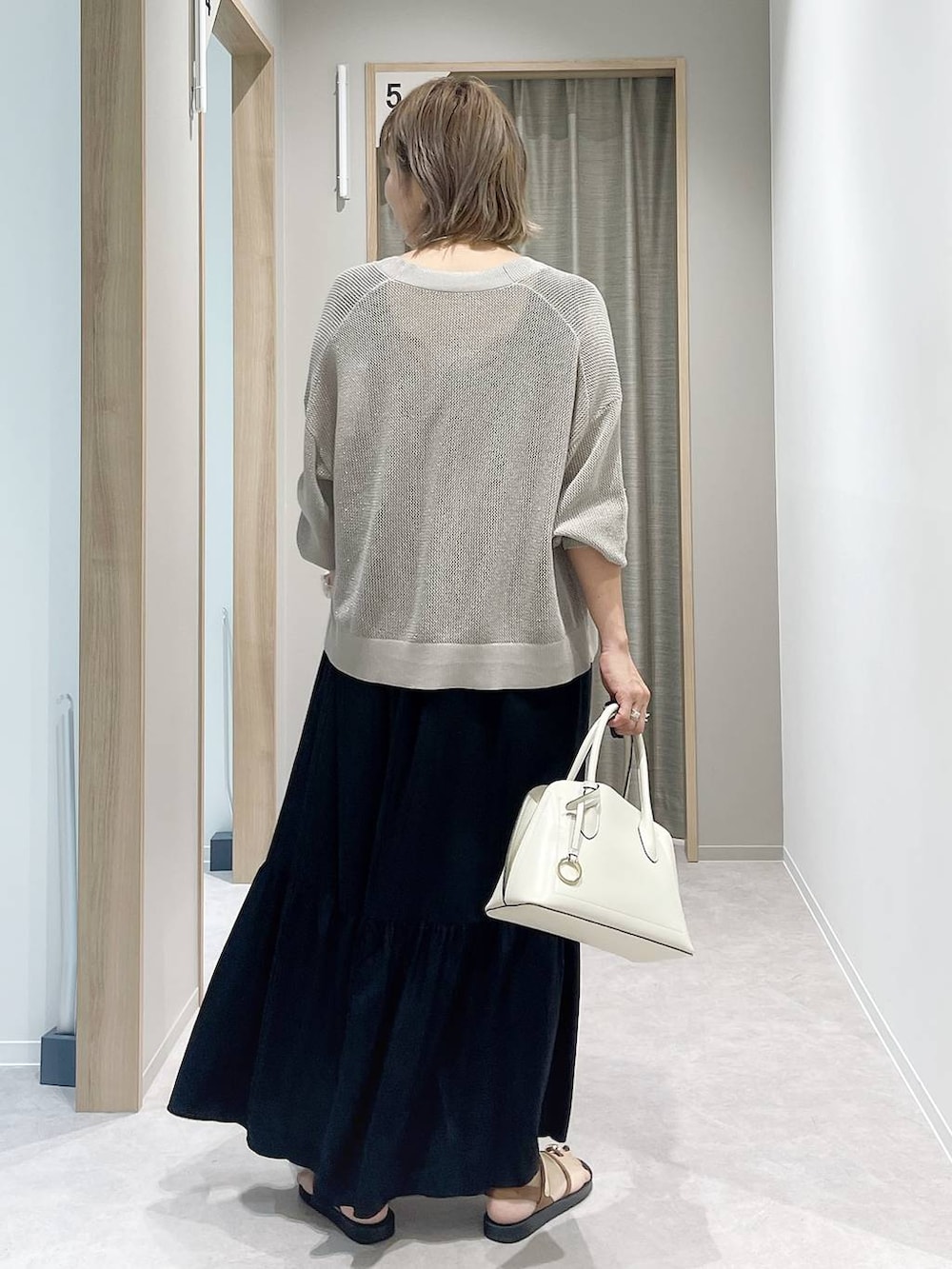 ホワイト系のショルダーバッグ、ブラウン系のカーディガン/ボレロ、ブラウン系のサンダルを着用したレディースの夏コーディネートの3枚目の写真