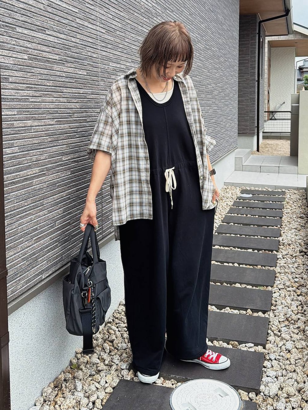 グレー系のトートバッグ、ブラック系のサロペット/オーバーオール、ブラウン系のシャツ/ブラウスを着用したレディースの夏コーディネートの2枚目の写真