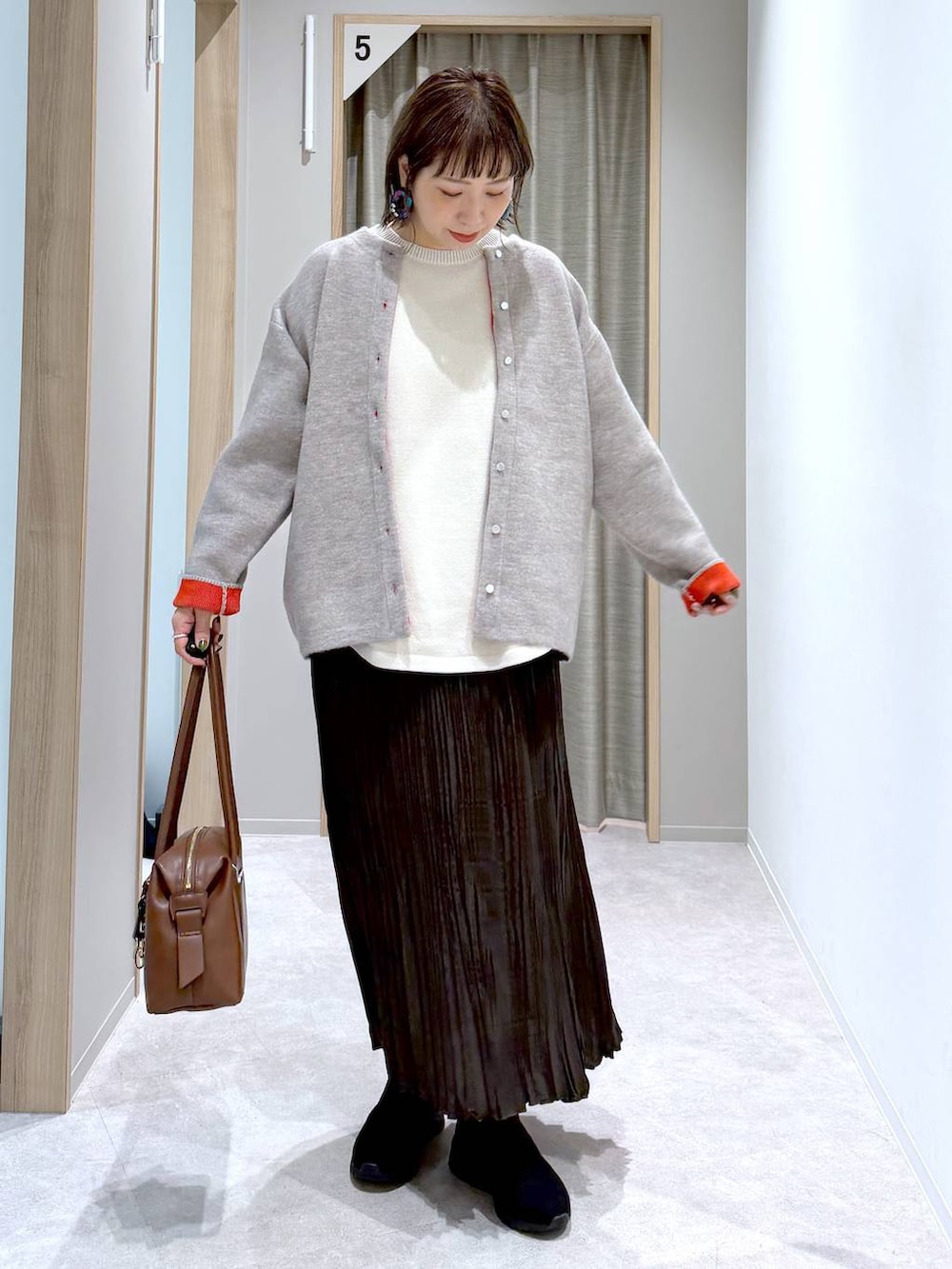 ベージュ系のニット/セーター、ブラウン系のボストンバッグ、ブラック系のブーツを着用したレディースの冬コーディネートの4枚目の写真