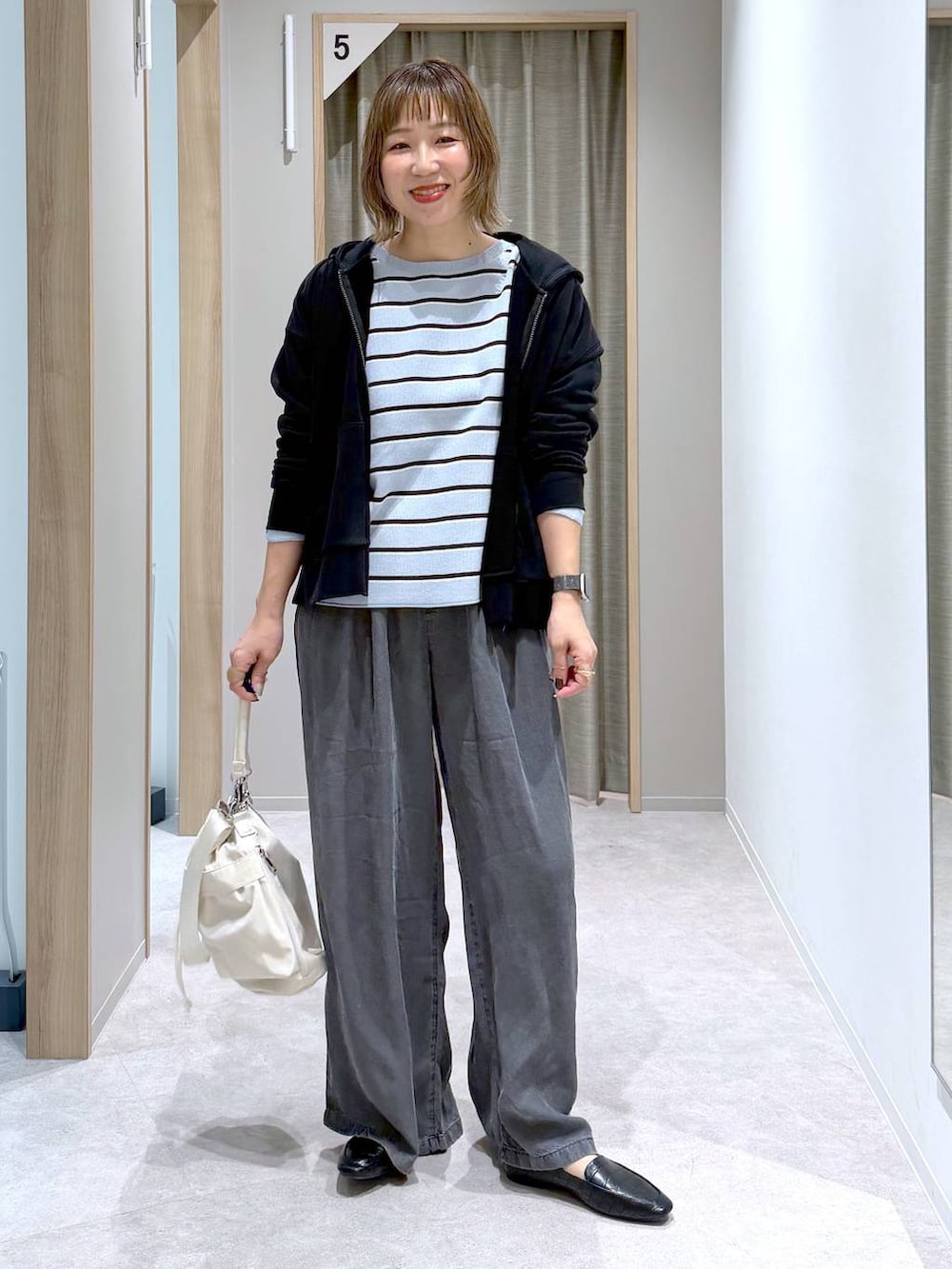 ブラック系のその他シューズ、ホワイト系のショルダーバッグ、ブルー系のニット/セーターを着用したレディースの春コーディネートの4枚目の写真