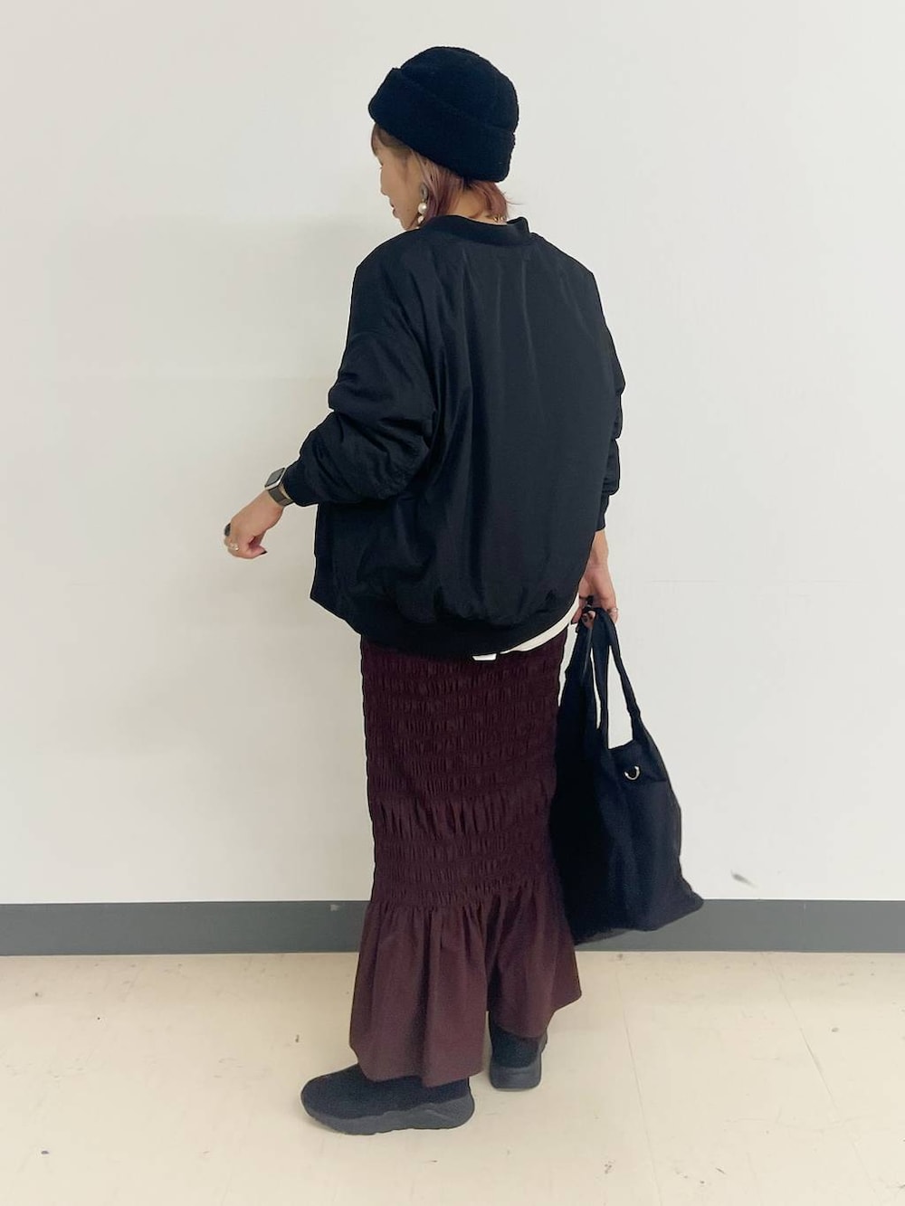 ブラック系のトートバッグ、ブラック系のブルゾン、ブラック系のブーツを着用したレディースの秋コーディネートの2枚目の写真