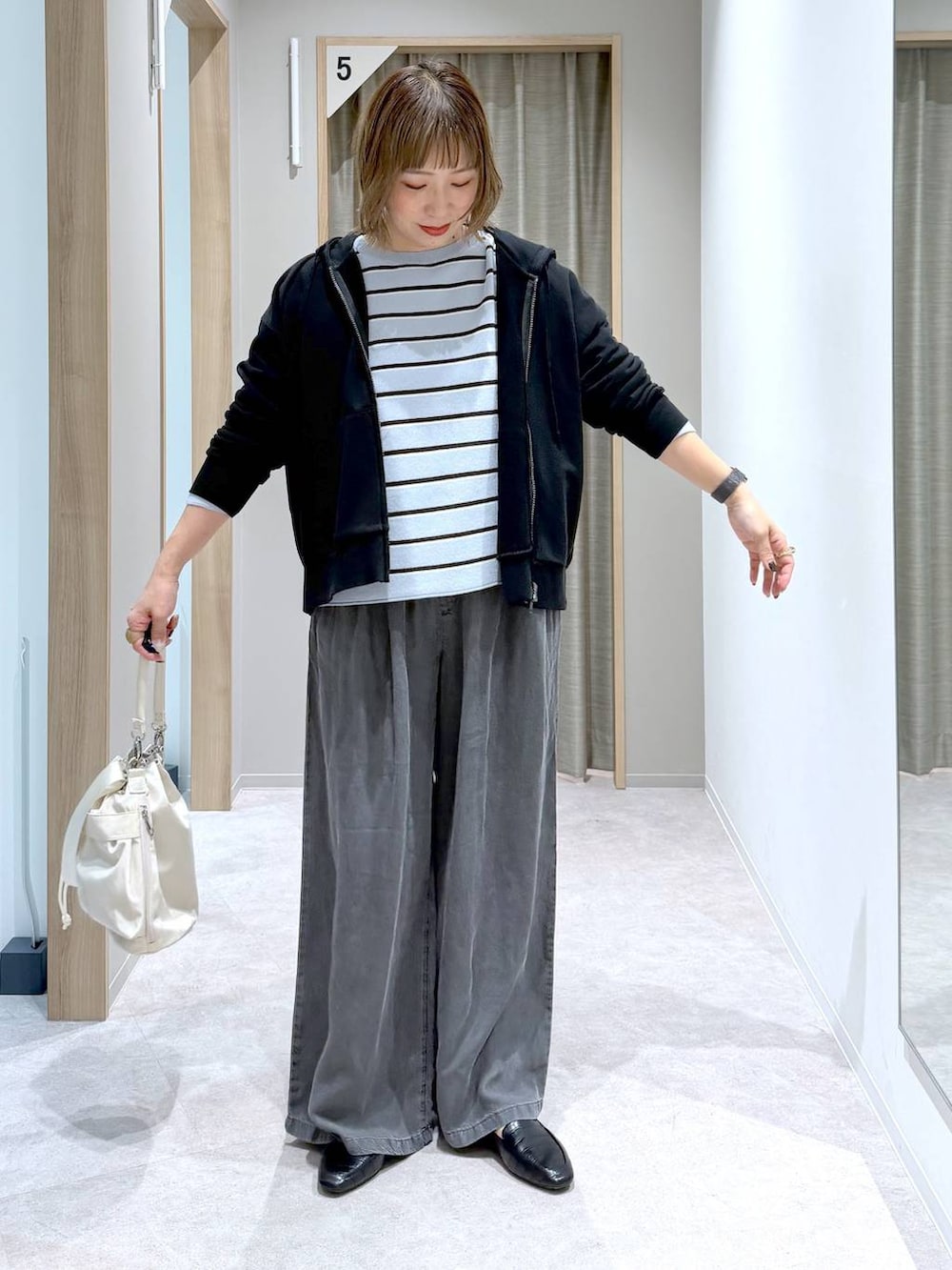 ブラック系のその他シューズ、ホワイト系のショルダーバッグ、ブルー系のニット/セーターを着用したレディースの春コーディネートの3枚目の写真