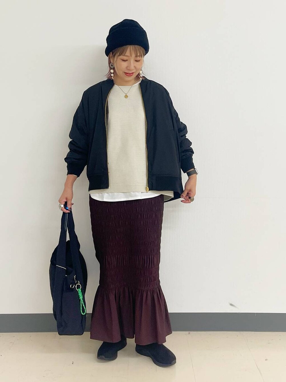 ブラック系のトートバッグ、ブラック系のブルゾン、ブラック系のブーツを着用したレディースの秋コーディネートの4枚目の写真