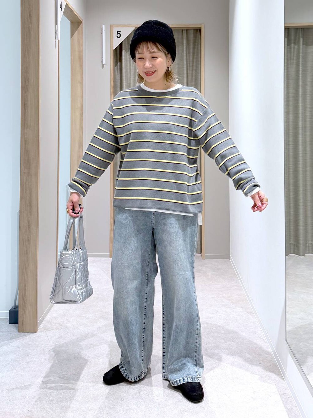 シルバー系のトートバッグ、ホワイト系のTシャツ/カットソー、ブラック系のモカシン/デッキシューズを着用したレディースの冬コーディネートの4枚目の写真