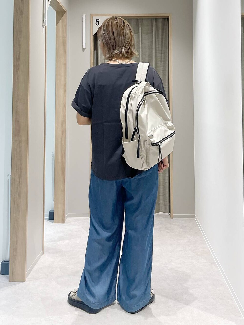 グレー系のTシャツ/カットソー、ホワイト系のバックパック/リュック、ベージュ系のサンダルを着用したレディースの夏コーディネートの3枚目の写真