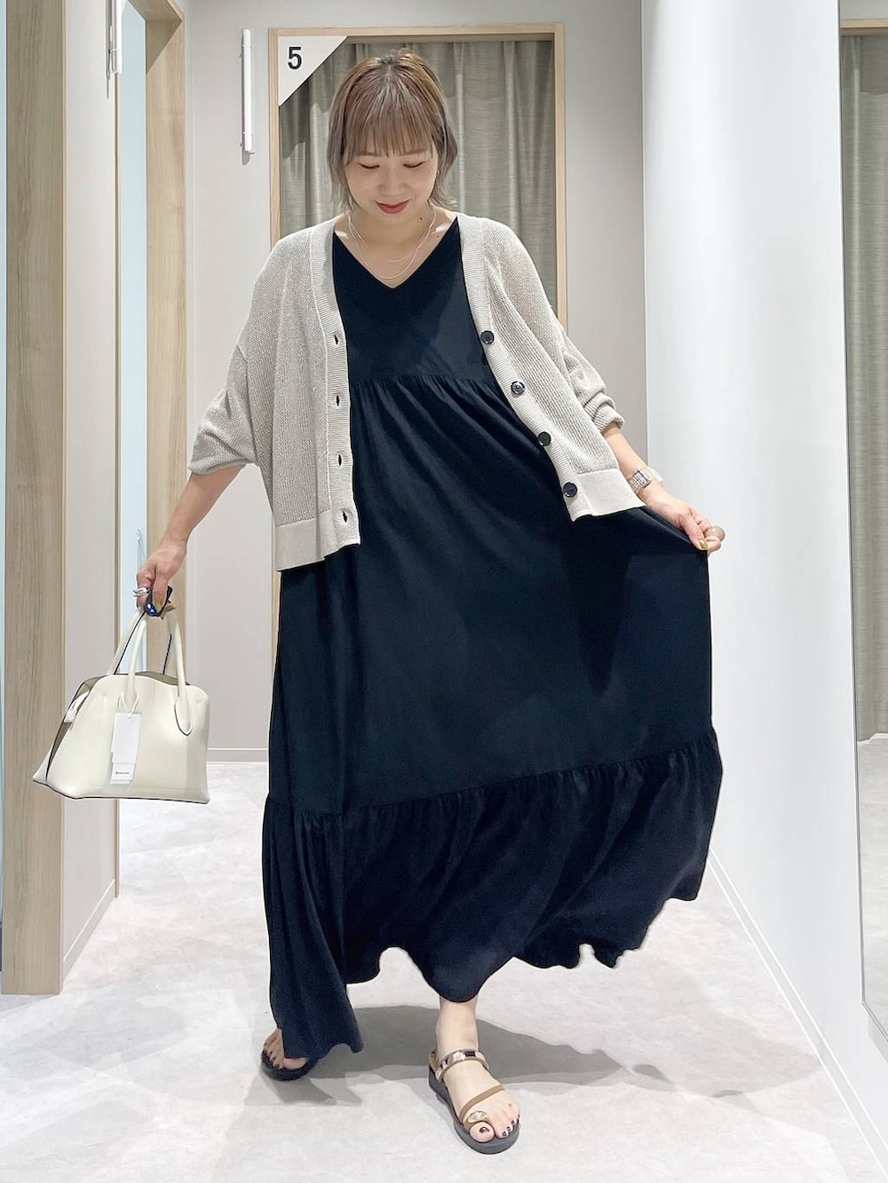 ホワイト系のショルダーバッグ、ブラウン系のカーディガン/ボレロ、ブラウン系のサンダルを着用したレディースの夏コーディネートの2枚目の写真