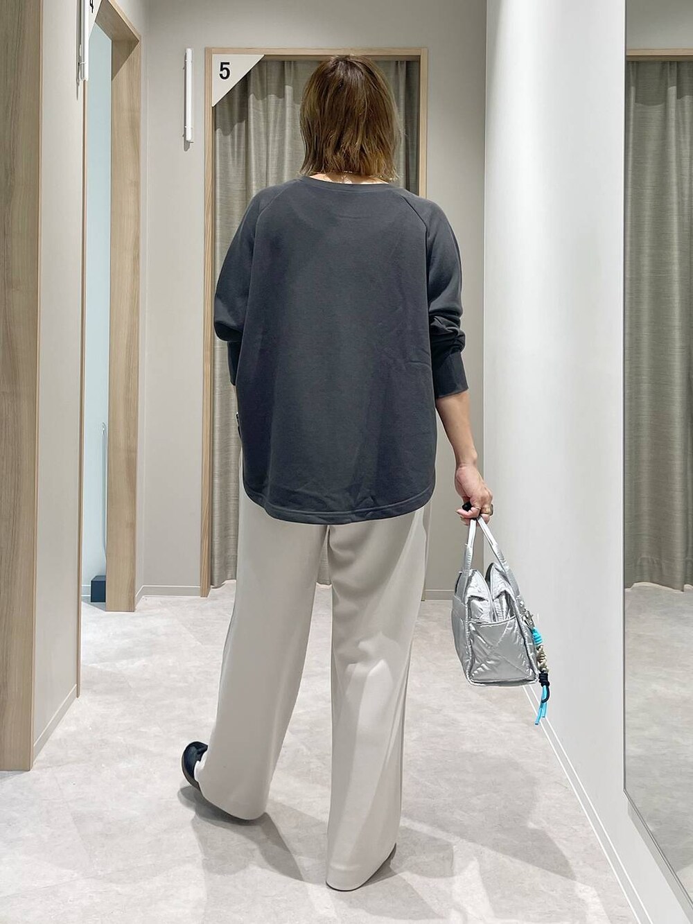 シルバー系のボストンバッグ、シルバー系のネックレスを着用したレディースの秋コーディネートの4枚目の写真