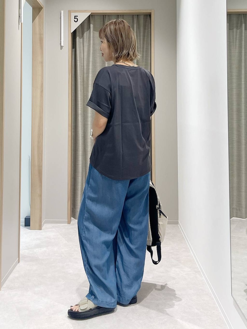 グレー系のTシャツ/カットソー、ホワイト系のバックパック/リュック、ベージュ系のサンダルを着用したレディースの夏コーディネートの2枚目の写真