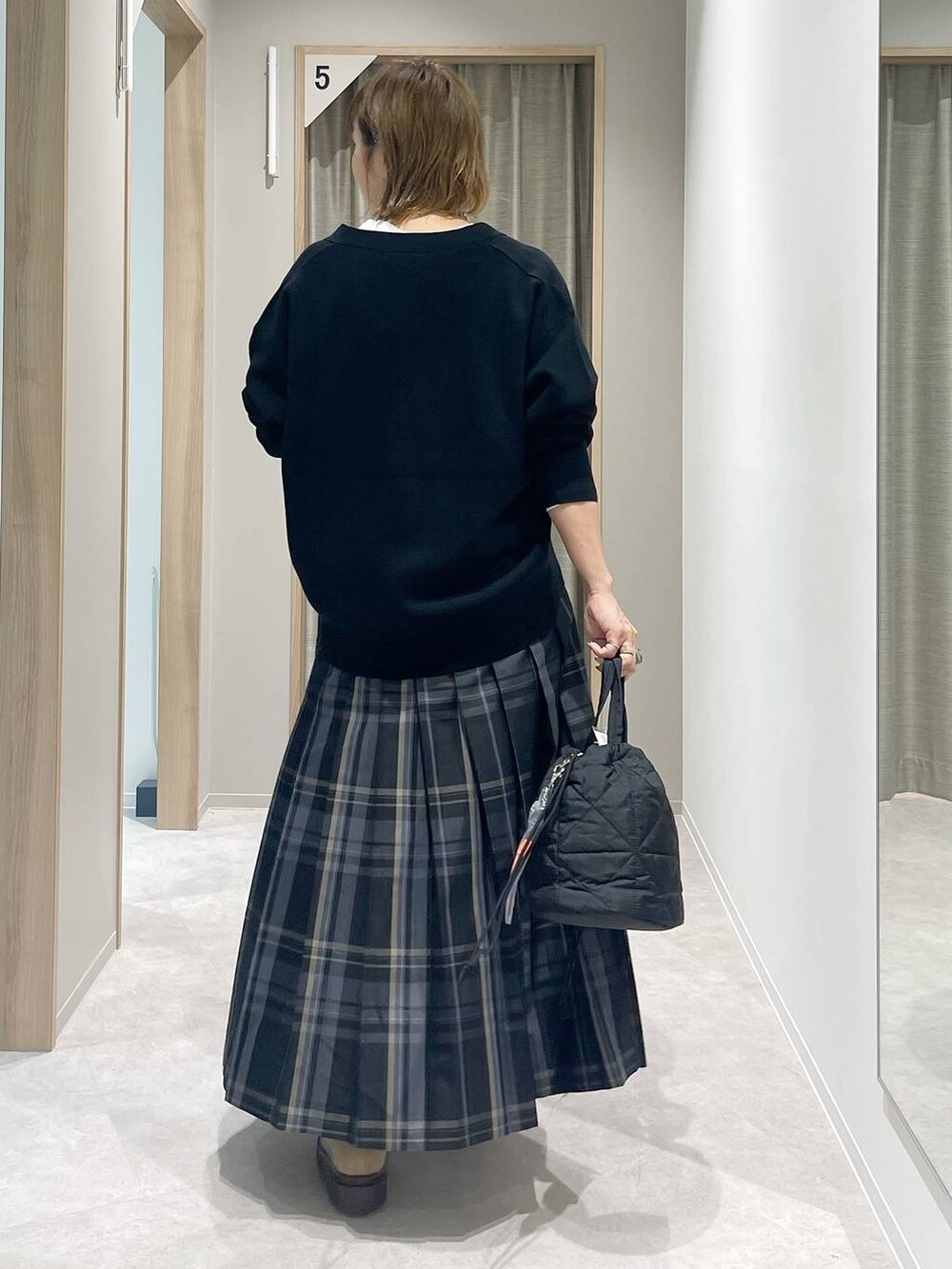 ブラック系のカーディガン/ボレロ、ブラック系のハンドバッグ、ホワイト系のTシャツ/カットソーを着用したレディースの秋コーディネートの3枚目の写真