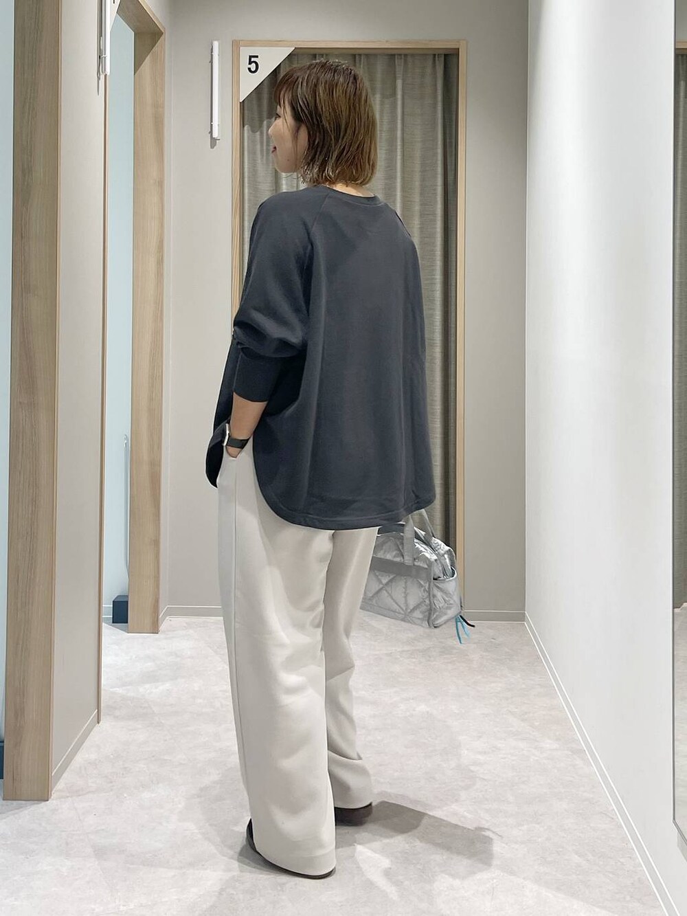 シルバー系のボストンバッグ、シルバー系のネックレスを着用したレディースの秋コーディネートの3枚目の写真