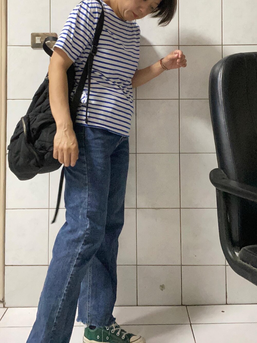 ブルー系のデニムパンツ、グリーン系のスニーカーを着用したレディースの夏コーディネートの2枚目の写真