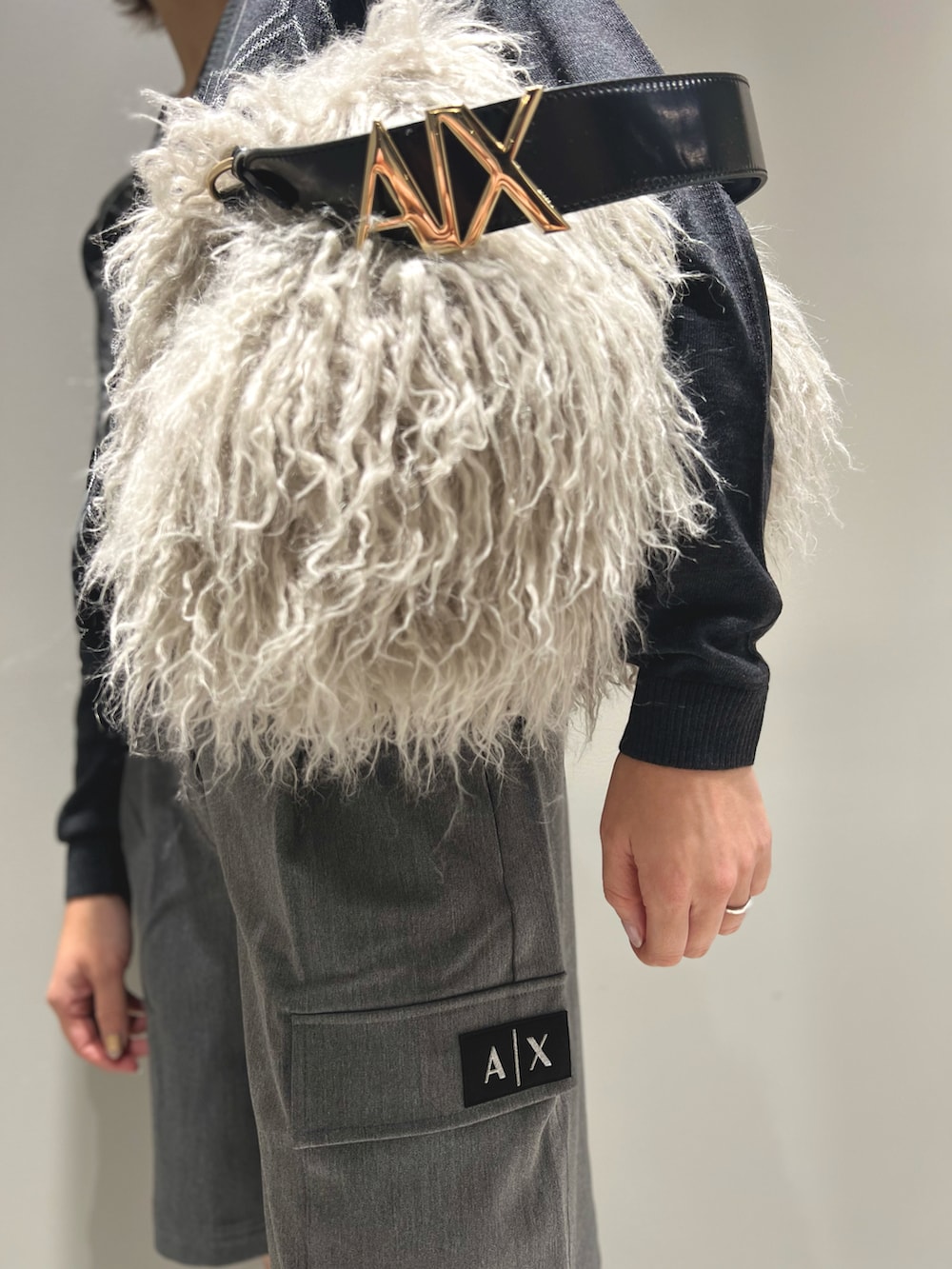 ベージュ系のハンドバッグ、グレー系のニット/セーター、グレー系のその他パンツを着用したレディースの秋コーディネートの2枚目の写真