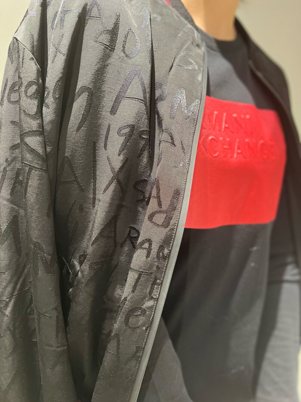 ブラック系のブルゾン、ブラック系のワンピース、ベージュ系のハンドバッグを着用したレディースの秋コーディネートの2枚目の写真