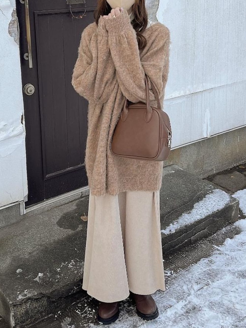 ベージュ系のカーディガン/ボレロ、ブラウン系のショルダーバッグ、ブラウン系のブーツを着用したレディースの冬コーディネートの2枚目の写真