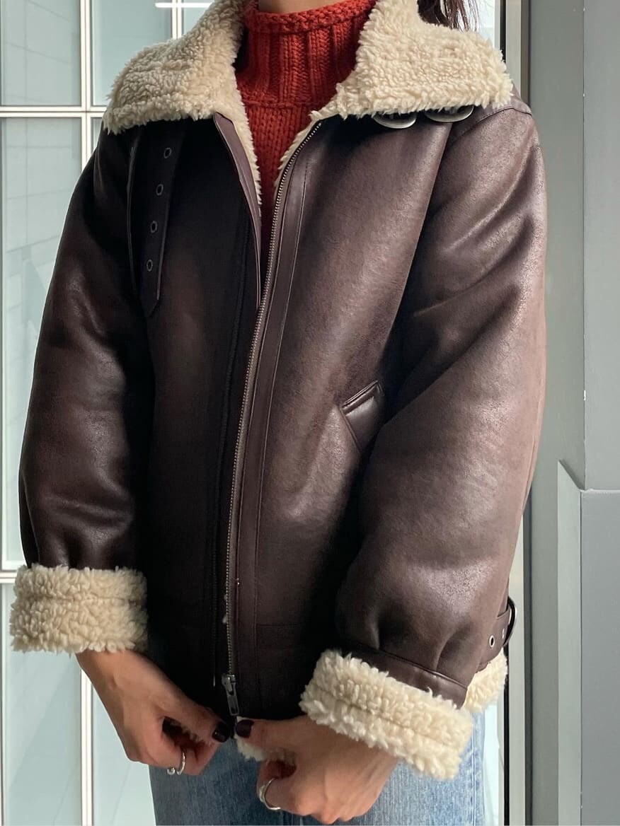 オレンジ系のニット/セーター、ブルー系のデニムパンツ、ホワイト系のTシャツ/カットソーを着用したレディースの秋コーディネートの3枚目の写真