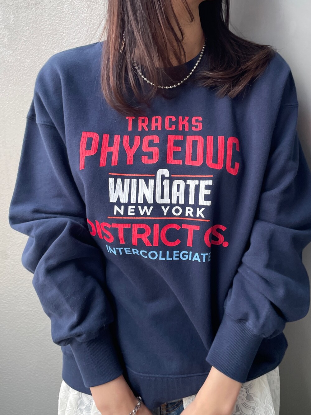 ホワイト系のワンピース、ブルー系のデニムパンツ、ベージュ系のハンドバッグを着用したレディースの冬コーディネートの4枚目の写真