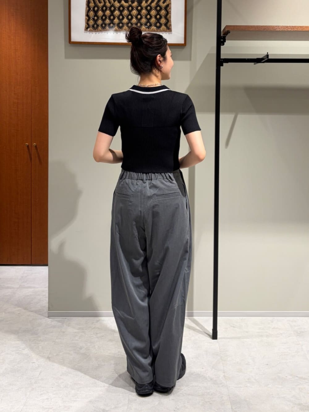 ブラック系のニット/セーター、グレー系のその他パンツ、その他のネックレスを着用したレディースの夏コーディネートの3枚目の写真