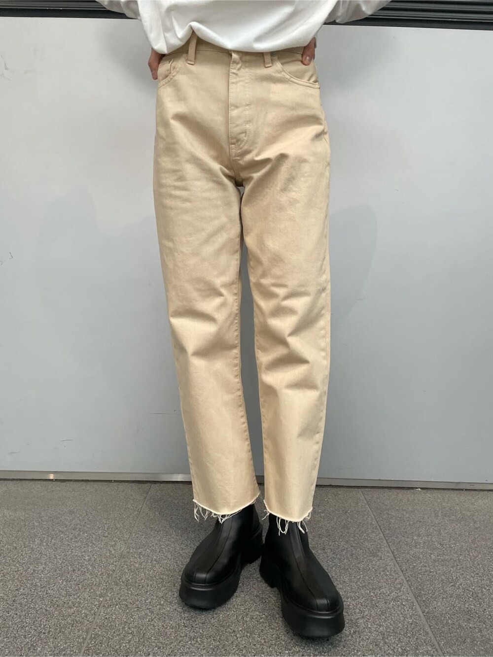 ブラック系のブーツ、ホワイト系のデニムパンツ、ホワイト系のTシャツ/カットソーを着用したレディースの冬コーディネートの2枚目の写真