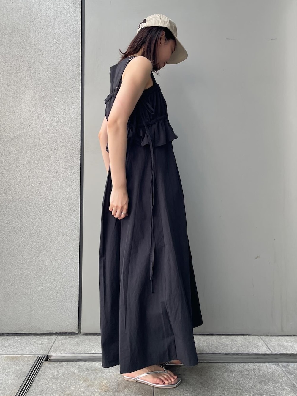 ブラック系のワンピース、シルバー系のサンダルを着用したレディースの春コーディネートの3枚目の写真