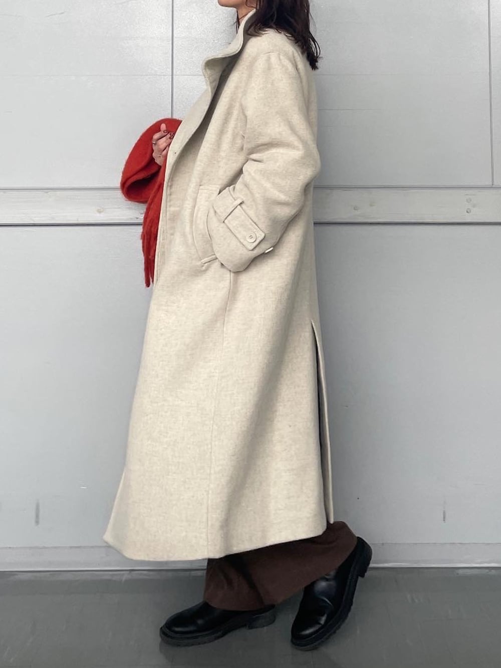 ホワイト系のその他アウター、ブラウン系のその他パンツ、オレンジ系のマフラーを着用したレディースの秋コーディネートの3枚目の写真