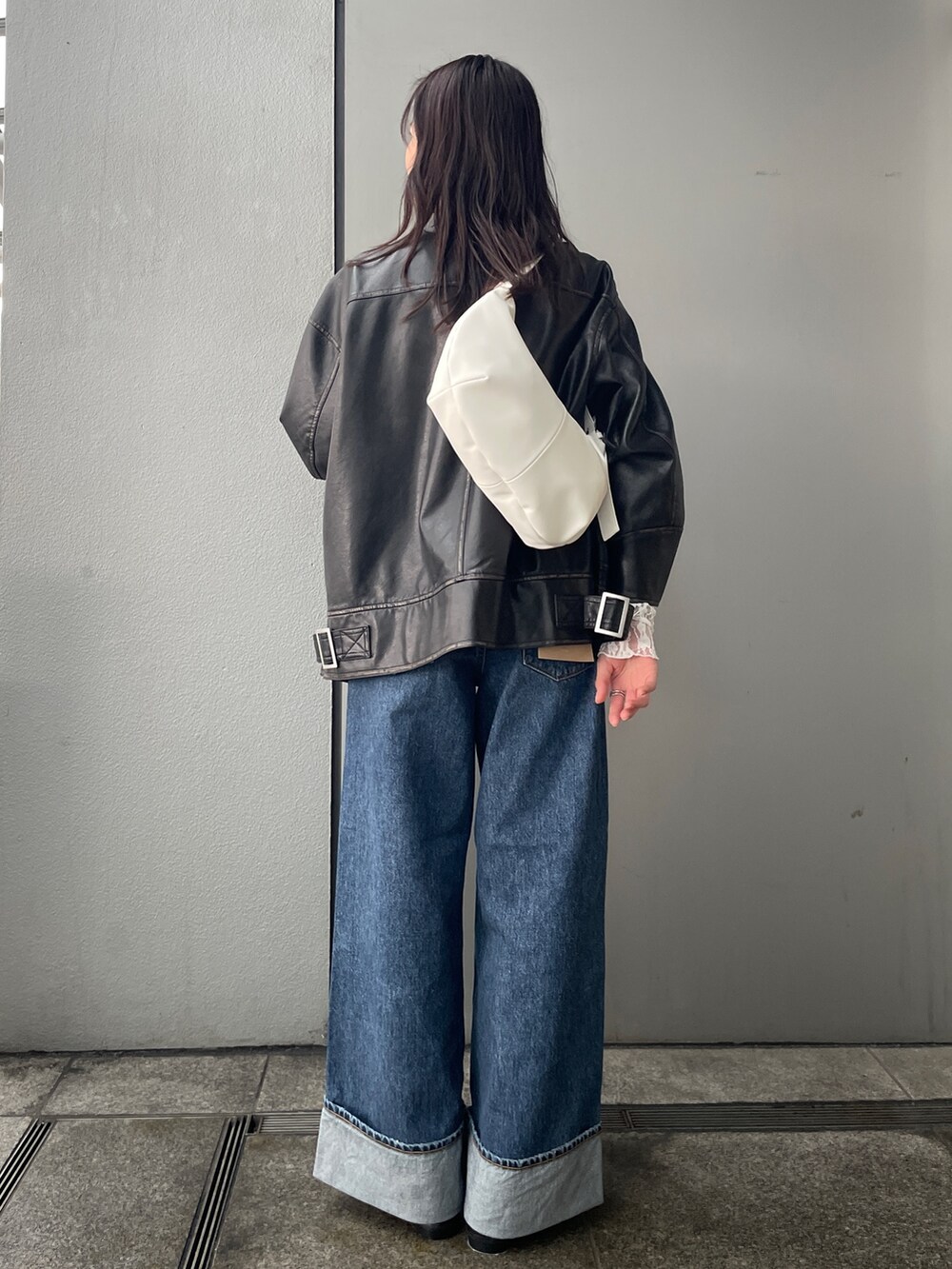 ブルー系のデニムパンツ、ブラック系のブルゾン、ブラック系のローファーを着用したレディースの冬コーディネートの2枚目の写真