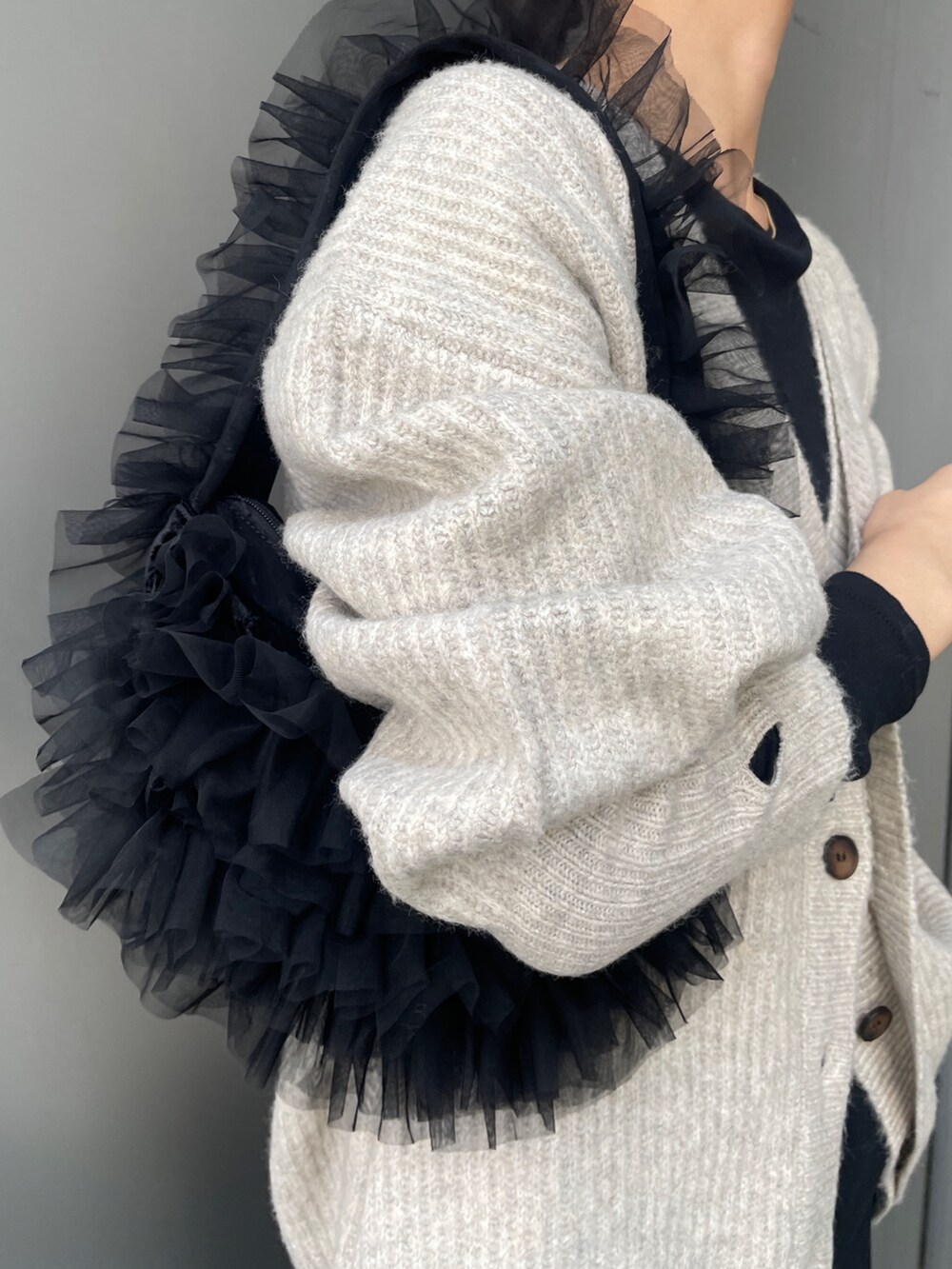 ホワイト系のカーディガン/ボレロ、ブラック系のスカート、ブラック系のTシャツ/カットソーを着用したレディースの秋コーディネートの4枚目の写真