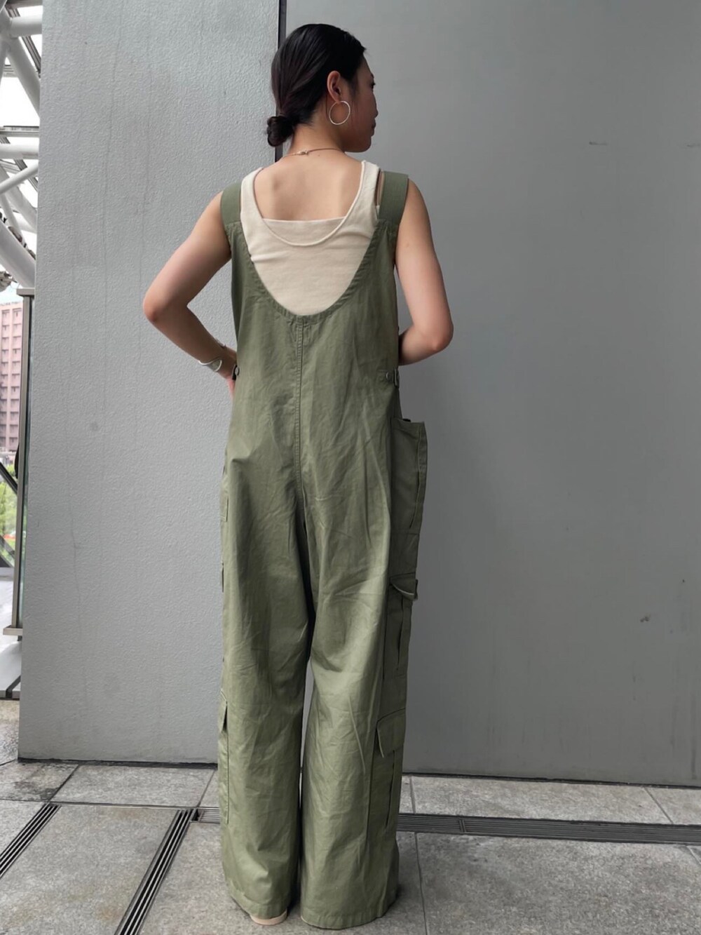 グリーン系のサロペット/オーバーオール、ブラウン系のベスト、ホワイト系のキャミソールを着用したレディースの夏コーディネートの3枚目の写真