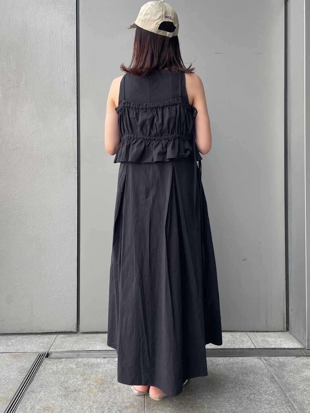 ブラック系のワンピース、シルバー系のサンダルを着用したレディースの春コーディネートの4枚目の写真