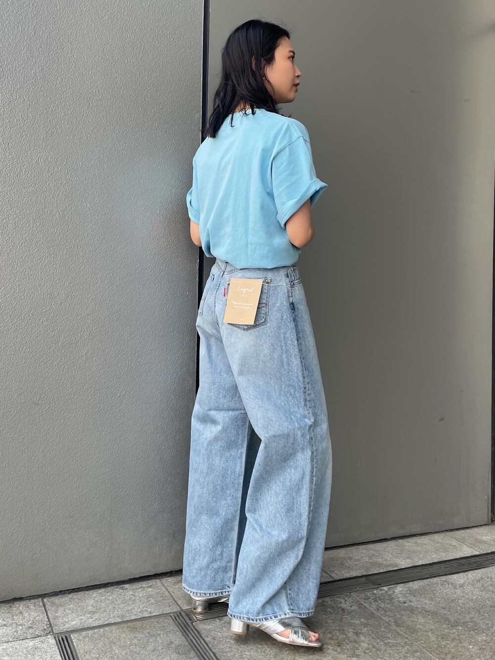 ブルー系のデニムパンツ、ブルー系のTシャツ/カットソー、シルバー系のサンダルを着用したレディースの夏コーディネートの2枚目の写真