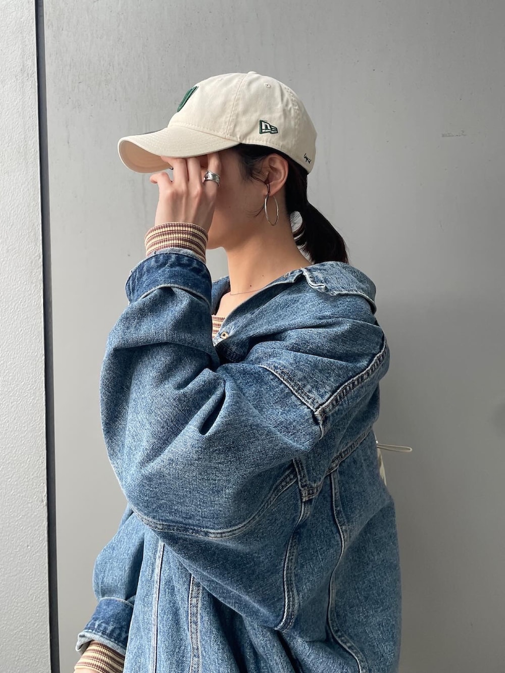 イエロー系のワンピース、ブルー系のデニムジャケット、ベージュ系のバックパック/リュックを着用したレディースの冬コーディネートの6枚目の写真