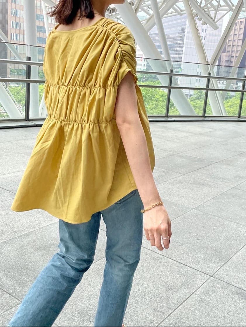 ブルー系のデニムパンツ、グリーン系のサンダル、イエロー系のシャツ/ブラウスを着用したレディースの夏コーディネートの2枚目の写真