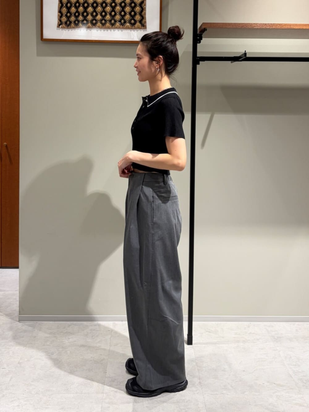 ブラック系のニット/セーター、グレー系のその他パンツ、その他のネックレスを着用したレディースの夏コーディネートの2枚目の写真